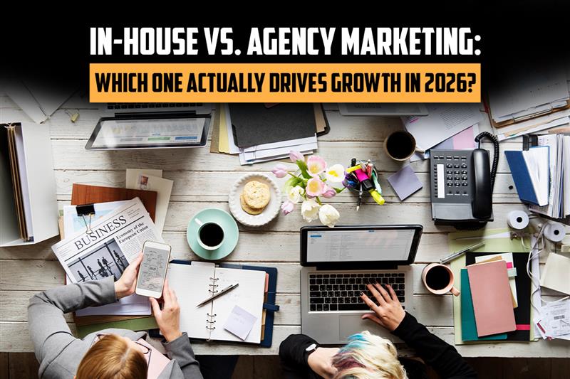 In-house vs agency marketing comparison showing workspace with laptops, documents and strategy planning for business growth in 2026